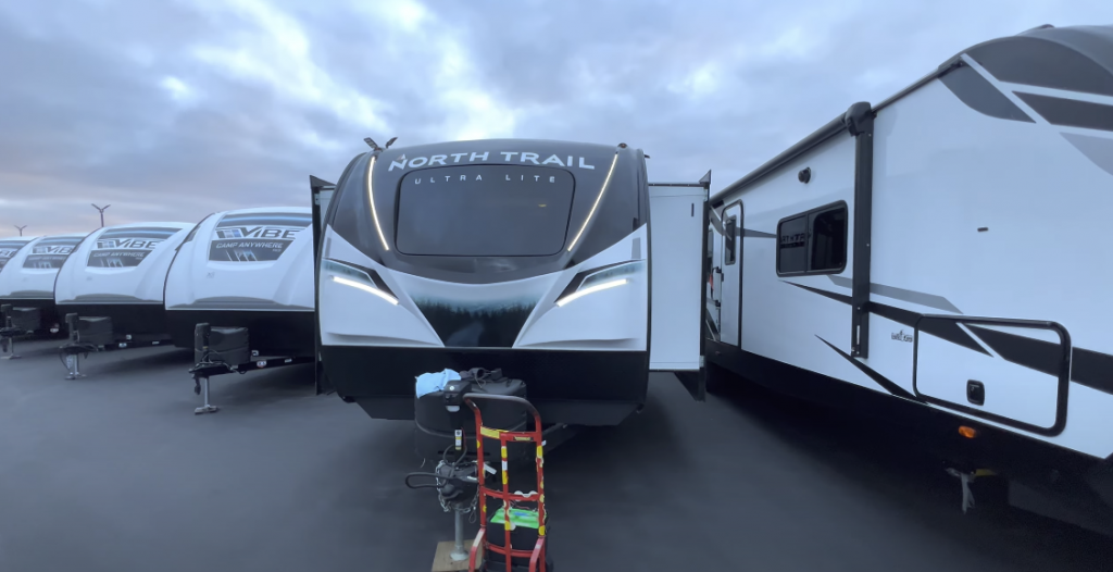 Black and white travel trailers arranged outside with the sky in the background