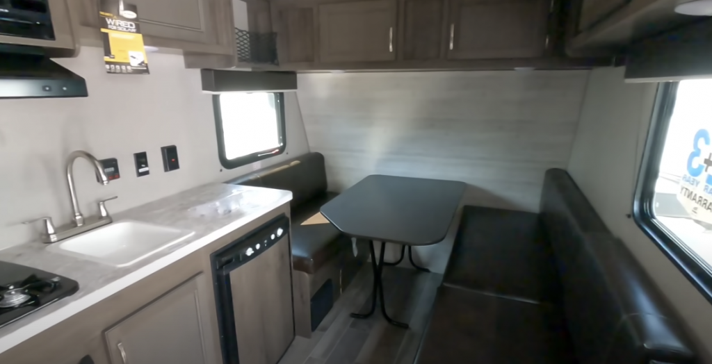 Interior view of the RV showing a sink, sofa, and table