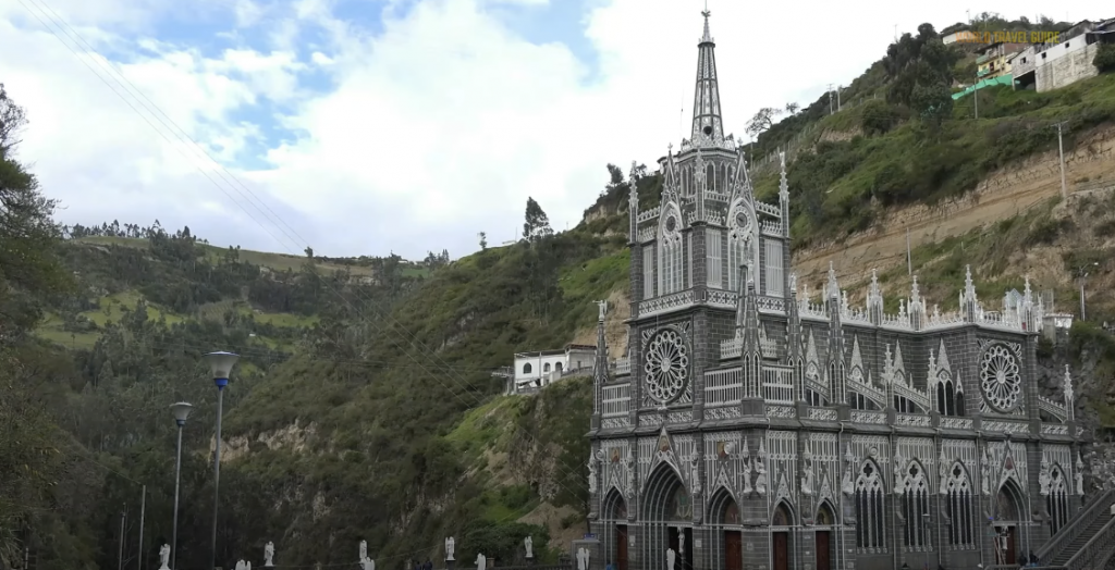 Photo of a grand castle-like building with mountains in the background