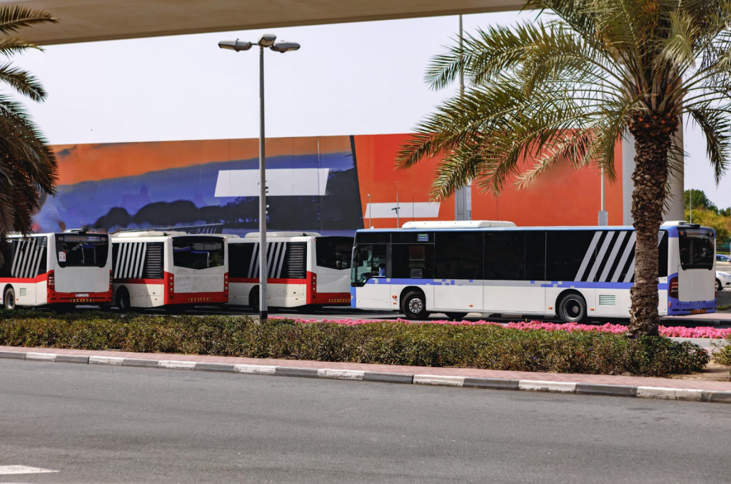 Several buses are waiting at the bus stop. 