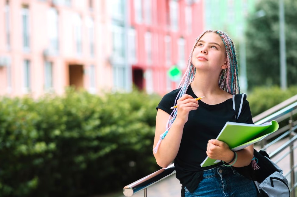 a dreamy student girl looking up with colorful hair