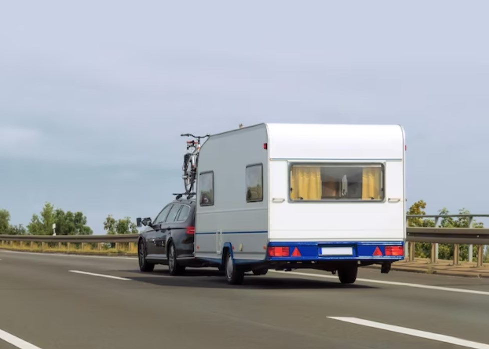 a caravan with a white RV trailer on the highway in Switzerland