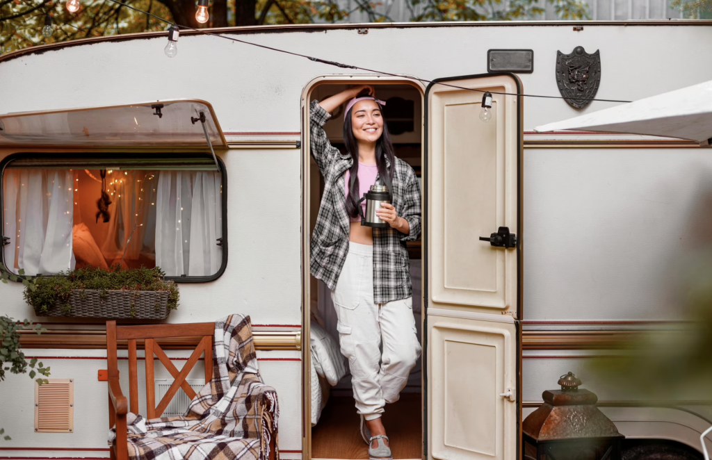 A woman standing in front of the travel trailer.